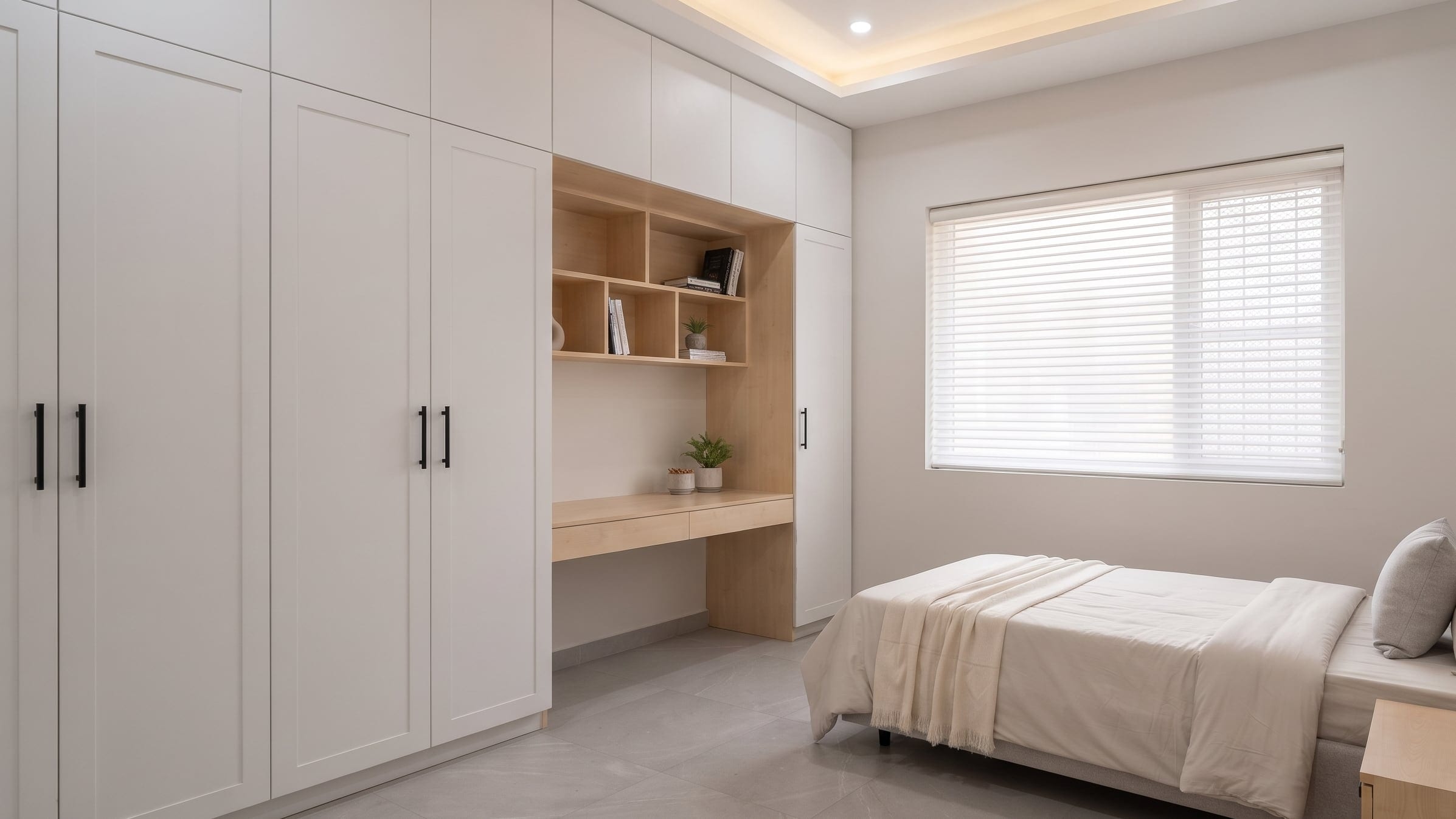 A bedroom with an upholstered headboard, a platform bed and a geometric sliding wardrobe