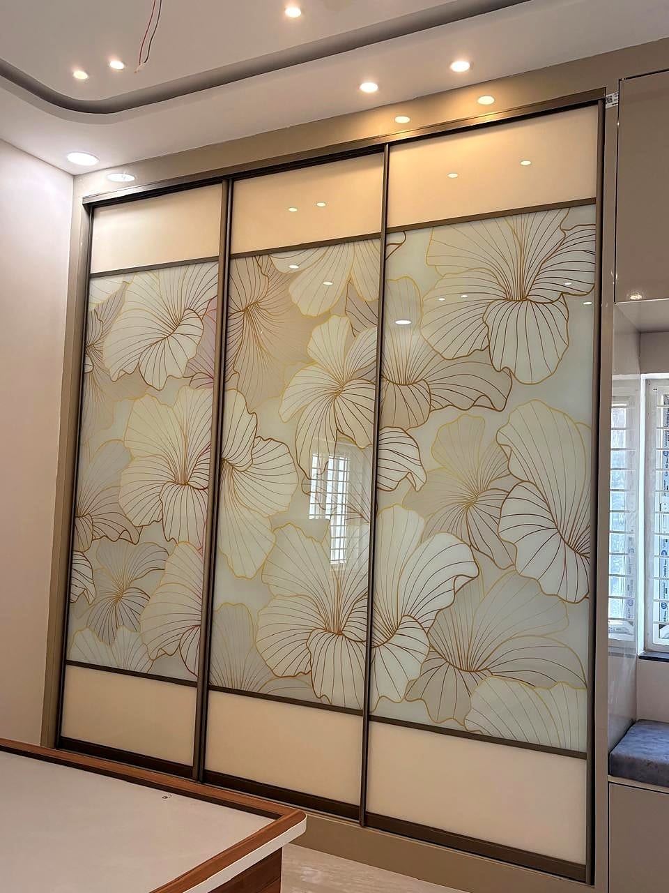 A floor-to-ceiling wardrobe in high-gloss white with an inlay motif