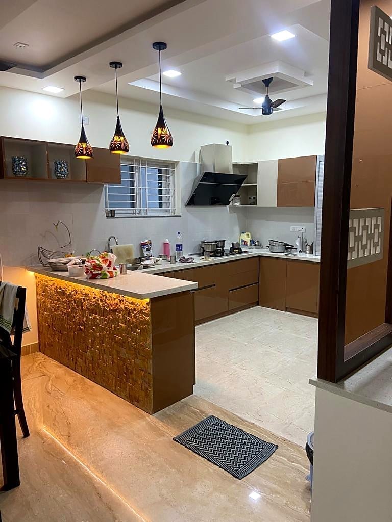 A modular kitchen with an island and pendant lights